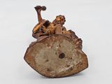 a figurine of a man riding a horse on a log