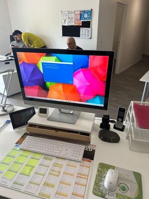 un écran d'ordinateur posé sur un bureau avec un clavier et une souris