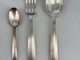 three silver spoons and two silver spoons on a table