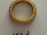 an image of a gold ring on a white surface with a price tag