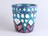 a blue vase with a pattern on it on a white surface