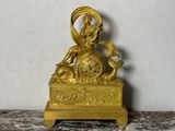 une horloge en or posée sur une table en marbre