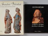 deux livres posés sur une table, à côté d'une statue représentant un homme et une femme