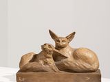 sculpture représentant un chat et un chien allongés sur une surface blanche