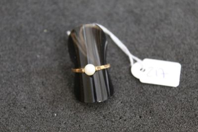 un petit objet noir orné d'un anneau en nacre