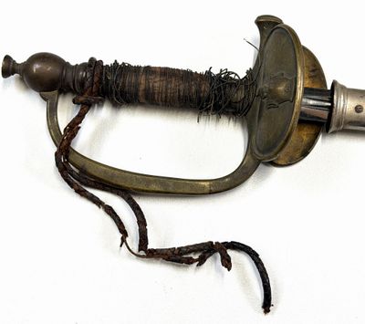 une dague d'aspect très ancien, à laquelle est attachée une corde