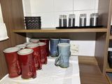 many cups and mugs sitting on a table in a room