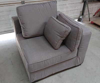 un canapé gris avec deux coussins dessus, dans un garage
