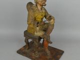 figurine représentant un homme assis sur un banc avec un chien