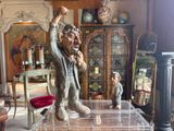 a statue of a man sitting on a table in a living room