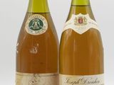 deux bouteilles de vin posées l'une à côté de l'autre sur une surface blanche