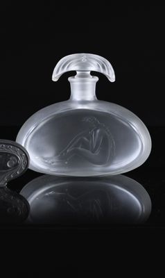 a glass bottle with a horse on it on a black surface