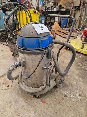 un aspirateur posé par terre dans le garage