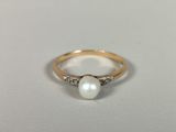 a close up of a gold ring with a pearl and diamonds