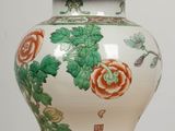 a white vase with orange flowers on it on a table