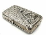 an old silver cigarette case sitting on top of a white surface