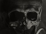 photographie en noir et blanc d'un crâne avec une pipe dans la bouche