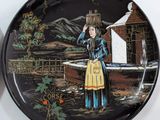 a decorative plate with a woman carrying a basket on her head