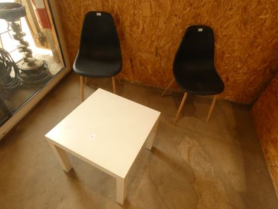 deux chaises noires et une table blanche dans une pièce