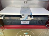 an image of a pizza oven sitting on top of a counter