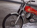 a man standing next to a red motorcycle in a garage