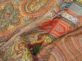 a close up picture of a colorful scarf on a bed