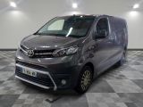 la camionnette grise est garée sur un sol en damier dans le garage