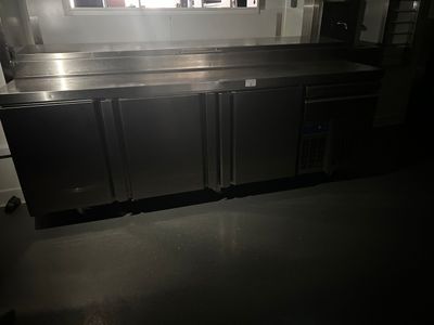 a kitchen with a stainless steel counter top and a refrigerator