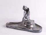 une sculpture en argent représentant un homme sur un bateau