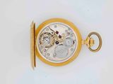 a close up of a pocket watch on a white surface