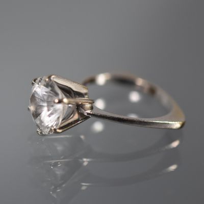 gros plan d'une bague en diamant sur une surface réfléchissante