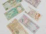 many different bank notes laid out on the table