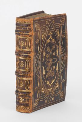 un vieux livre dont la couverture est ornée d'un motif décoratif