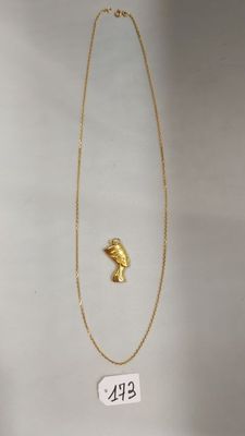 Gros plan sur un collier en or orné d'un oiseau