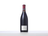 a bottle of red wine sitting on top of a white table