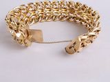 a close up of a gold chain bracelet with a lock on it