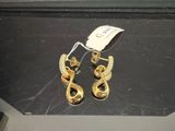 une paire de boucles d'oreilles dorées ornées de diamants, exposée dans une bijouterie