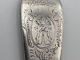 a silver spoon with a design on it sitting on a table