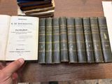 une personne tenant une pile de vieux livres posée sur une table