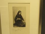 une vieille photo d'une femme assise sur une chaise, les mains posées sur les genoux