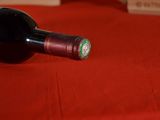 a bottle of wine sitting on a table with a red cloth