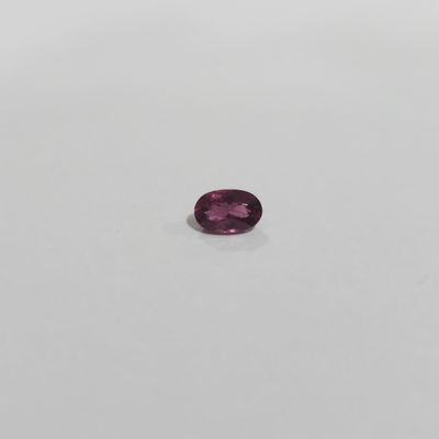 a purple sapphire stone on a white surface