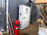 un extincteur rouge à côté d'un bâtiment métallique