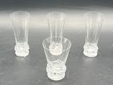 four glasses sitting on a table with a black background