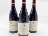 trois bouteilles de vin posées sur une table l'une à côté de l'autre