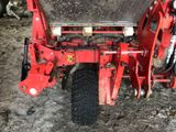 a red tractor that is parked in the dirt
