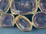 a close up of a purple broochle on a blue surface