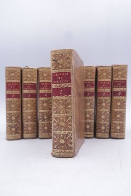 plusieurs vieux livres sont alignés sur une surface blanche