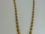 a gold chain necklace with a knot design on a white background