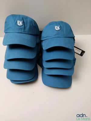 a pair of blue baseball caps sitting on top of a white table